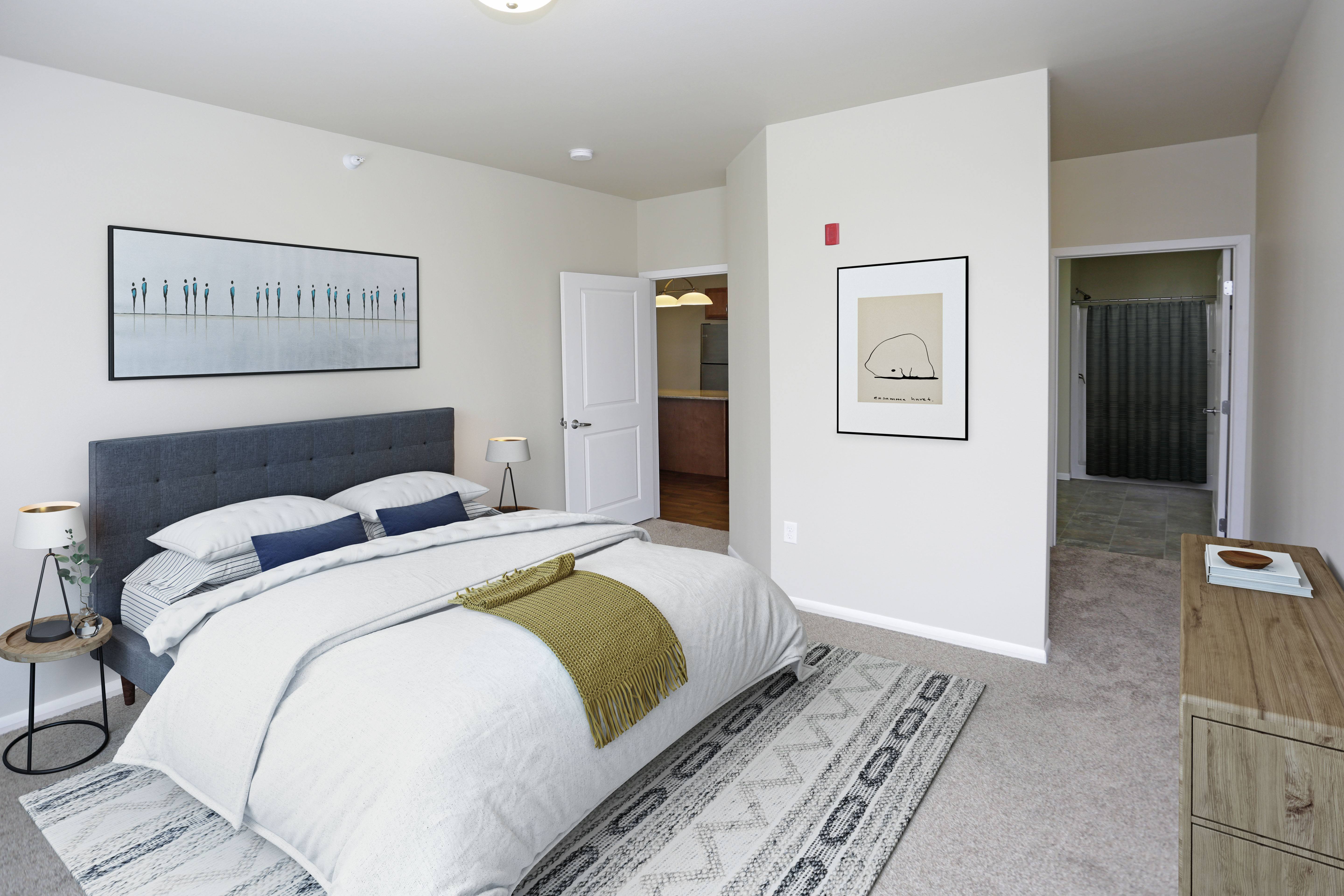 A bedroom with a large bed and a painting on the wall.